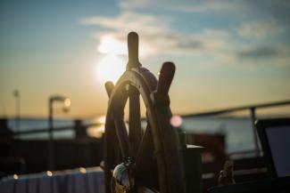 brown wooden ship's wheel by orbtal media courtesy of Unsplash.