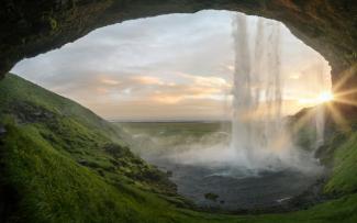 waterfalls near cave at daytime by Joshua Sortino courtesy of Unsplash.